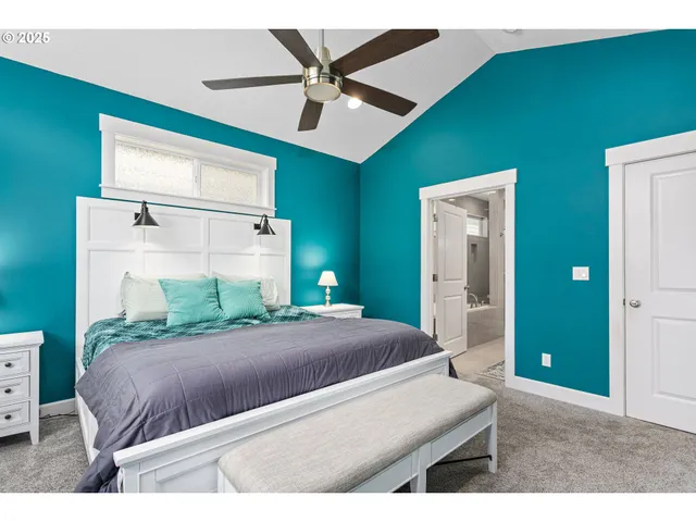 a bed room with a bed and a ceiling fan