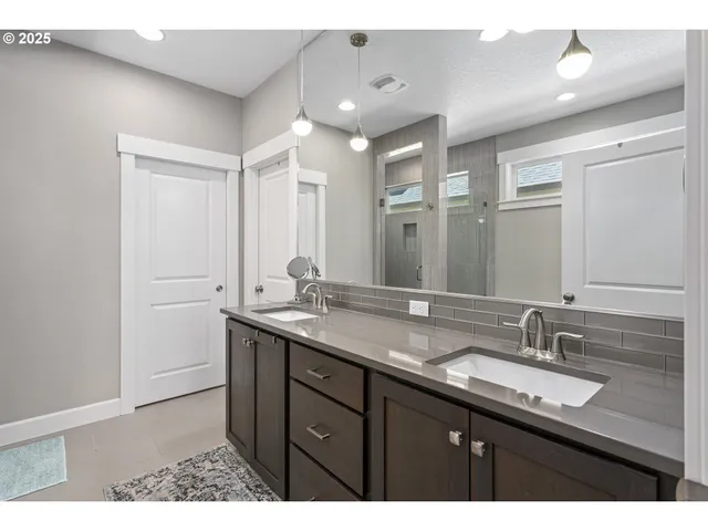 a bathroom with a granite countertop sink double and mirror