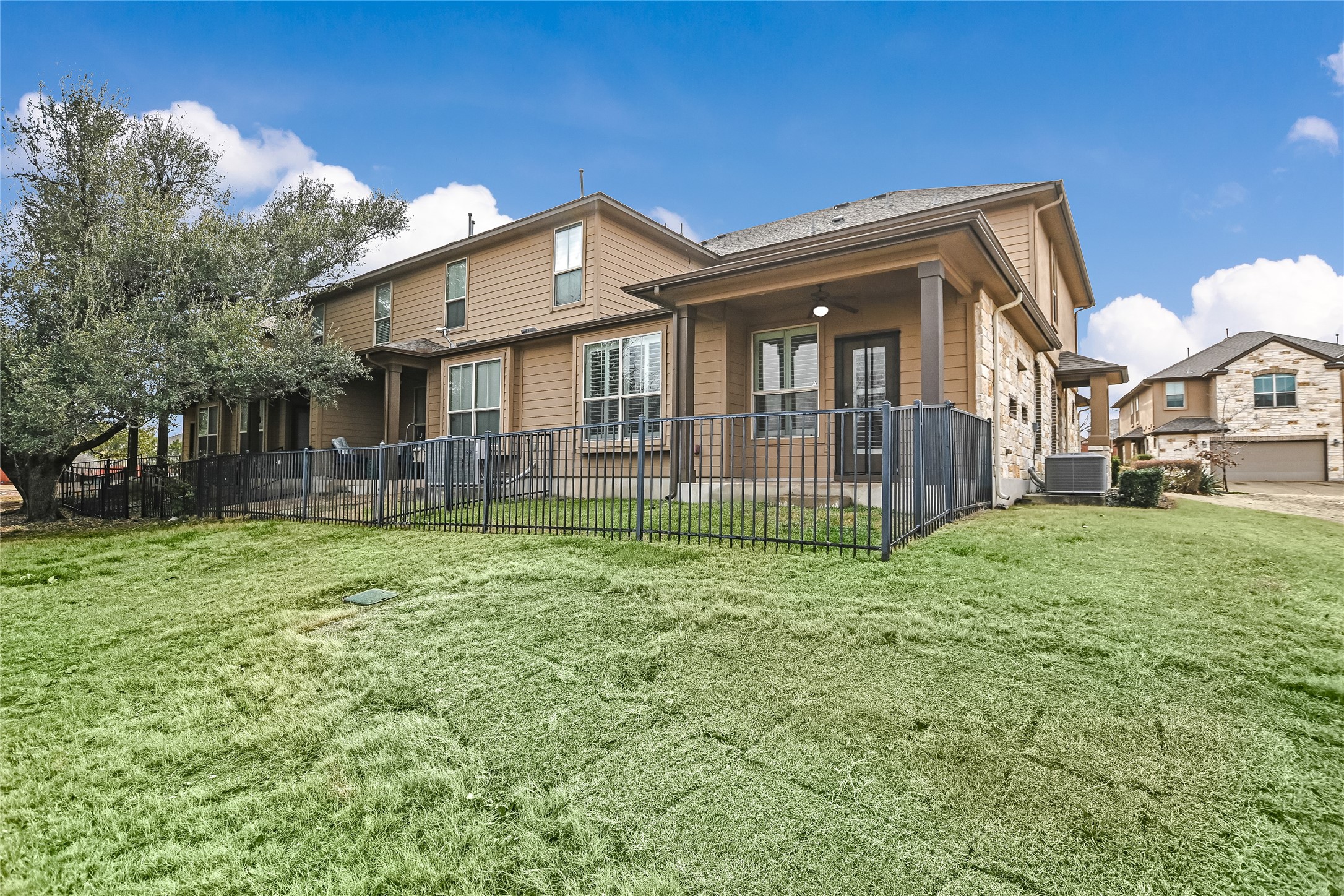 14001 Avery Ranch Boulevard, Unit 1601 Austin, TX 78717 - Photo 17 of 25 Back of property featuring a ceiling fan and stone siding with access to large common ground area.