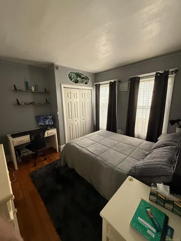 a bedroom with a bed and flat tv screen on the dresser