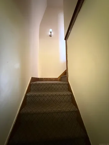 a view of a hallway with wooden floor and a window