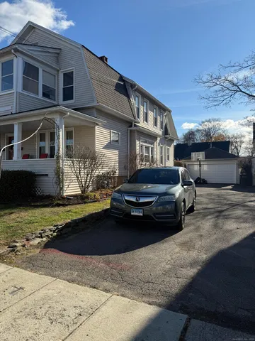 a car parked in front of a white house
