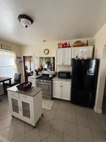 a kitchen with a sink dishwasher stove and white cabinets