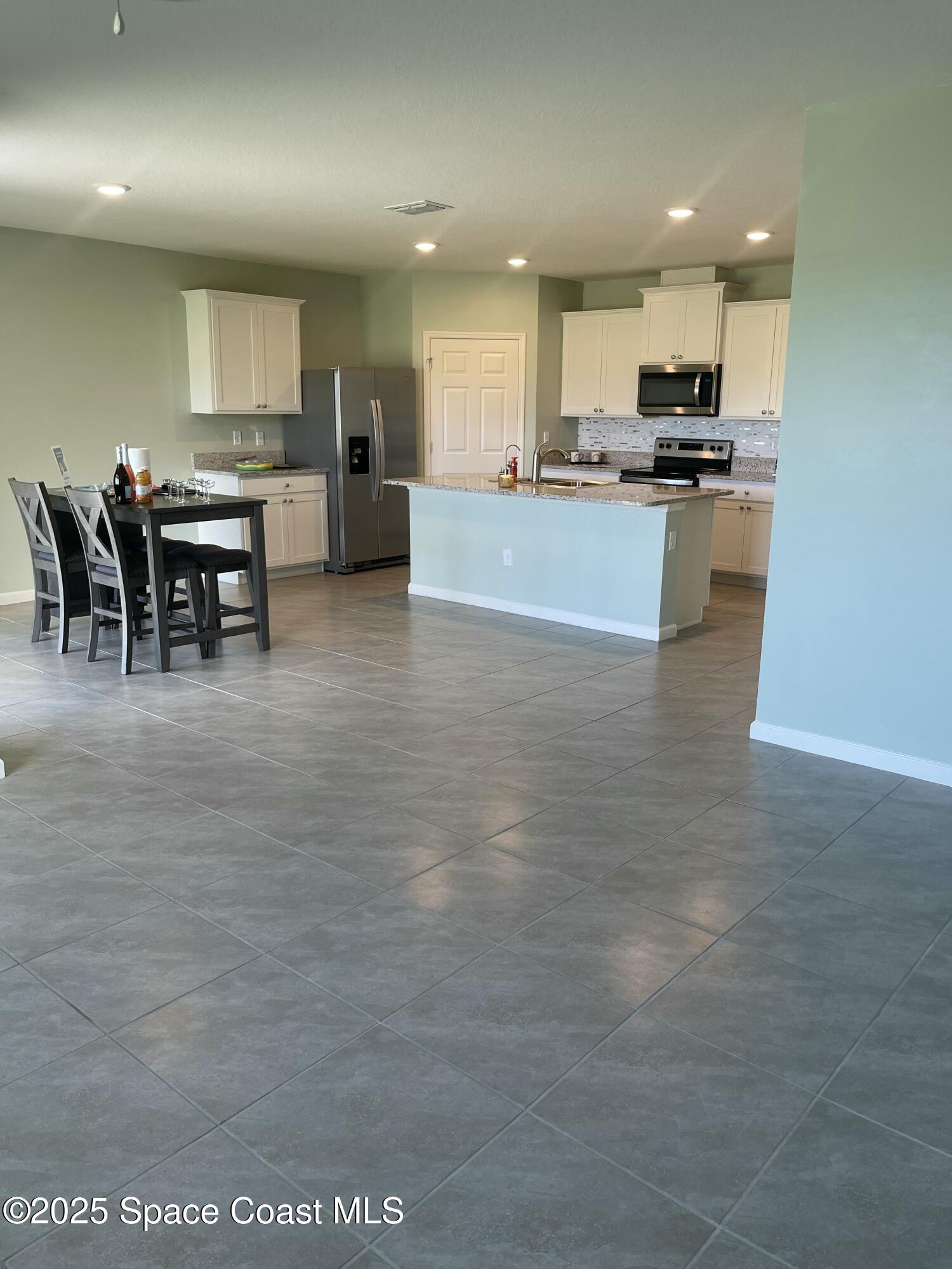 7055 Topaz Drive Grant-Valkaria, FL 32949 - Photo 14 of 24 a view of kitchen with stainless steel appliances granite countertop a stove and a refrigerator