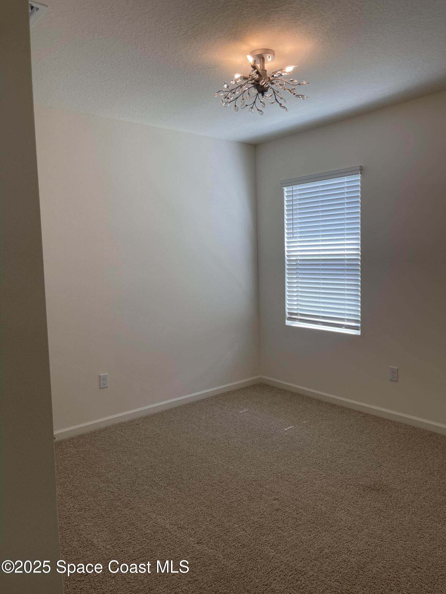 7055 Topaz Drive Grant-Valkaria, FL 32949 - Photo 6 of 24 an empty room with windows and fan