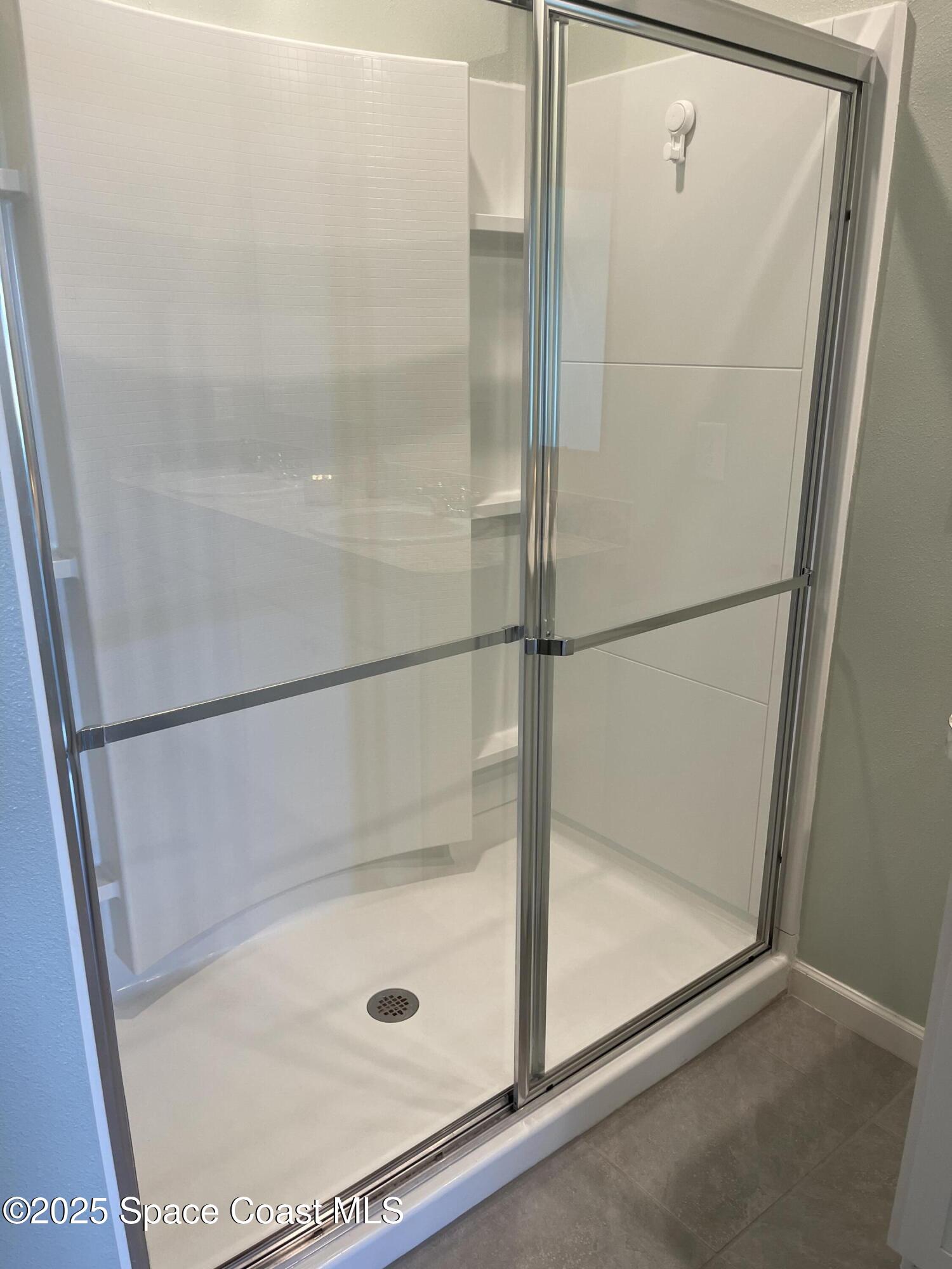 7055 Topaz Drive Grant-Valkaria, FL 32949 - Photo 7 of 24 a bathroom with a glass shower door