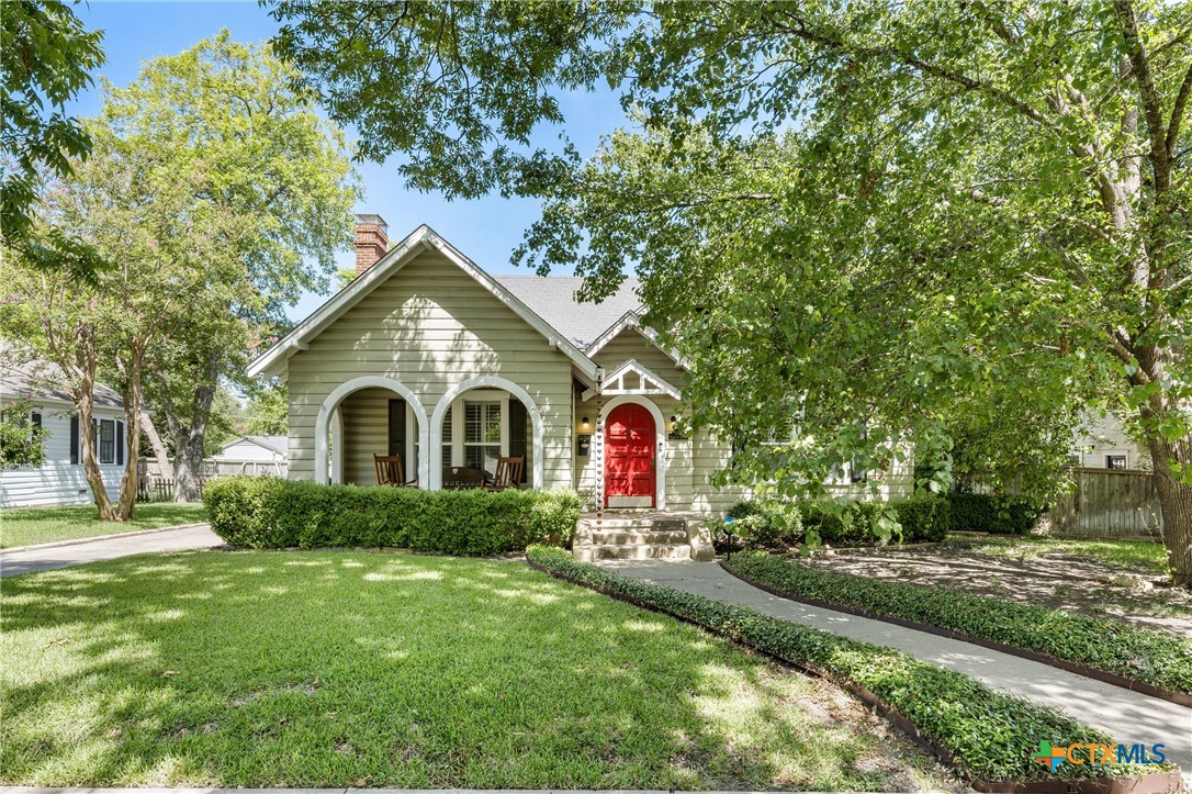 a front view of a house with yard and green space