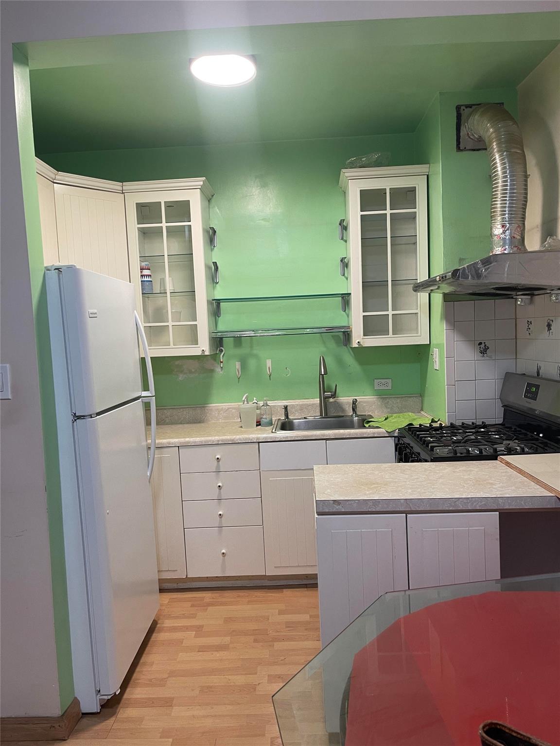 134-54 Maple Avenue, Unit 2S Queens, NY 11355 - Photo 9 of 18 a kitchen with a refrigerator and a sink