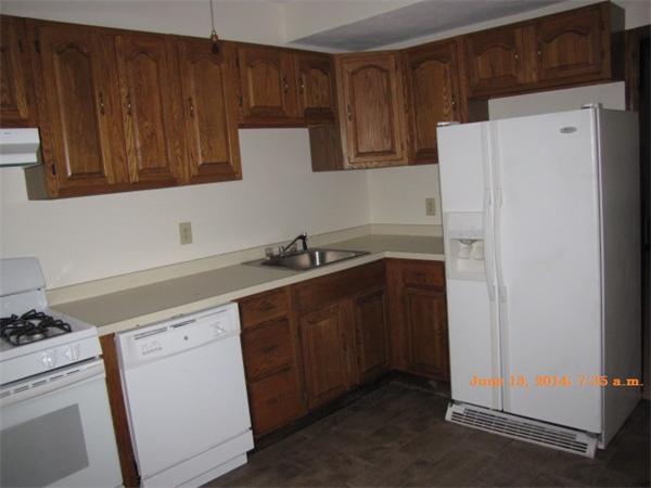 325 Mammoth Road, Unit 2 Lowell, MA 01854 - Photo 7 of 9 a kitchen with sink a refrigerator and cabinets