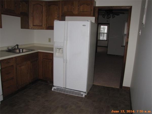 325 Mammoth Road, Unit 2 Lowell, MA 01854 - Photo 8 of 9 a kitchen with a refrigerator sink and cabinets