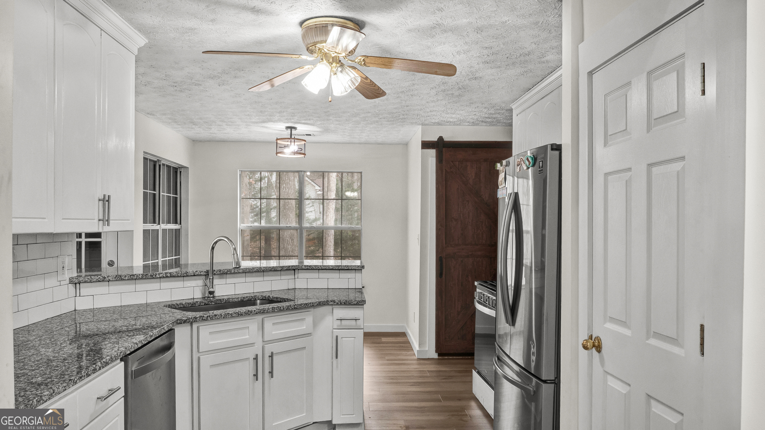 192 Duncans Mill Road Locust Grove, GA 30248 - Photo 5 of 17 a kitchen with stainless steel appliances granite countertop a sink a refrigerator and a granite counter tops