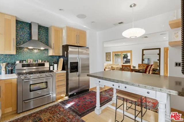 a kitchen with stainless steel appliances granite countertop a stove a sink and a refrigerator