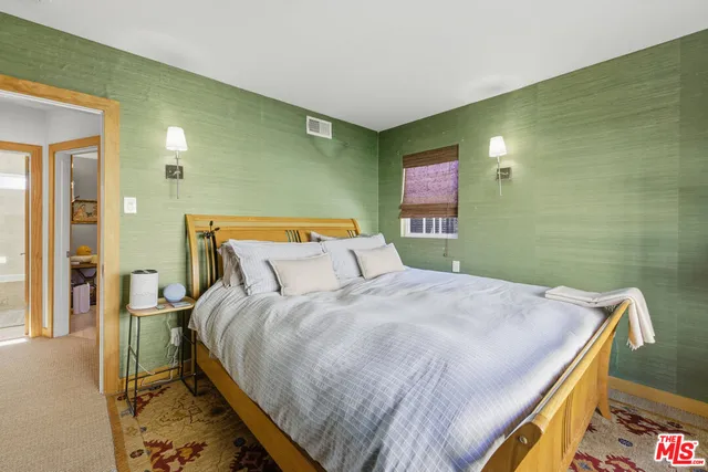 a bedroom with a bed and a painting on the wall