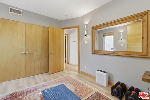 a view of a bedroom with wooden floor and a cabinet