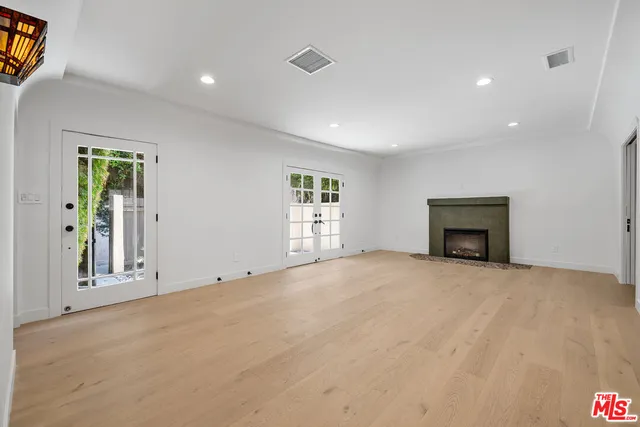 a view of an empty room with a fireplace and a window
