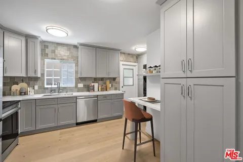 a kitchen with stainless steel appliances granite countertop white cabinets and window