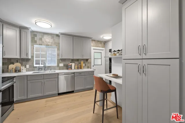 a kitchen with stainless steel appliances granite countertop white cabinets and window
