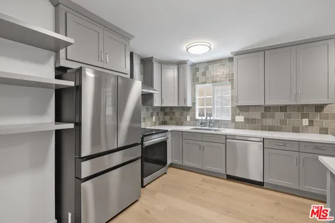 a kitchen with stainless steel appliances granite countertop a refrigerator sink and stove