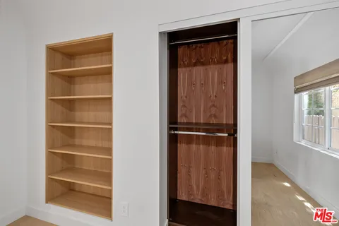 a view of walk in closet with empty racks