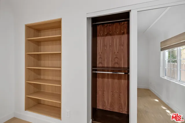 a view of walk in closet with empty racks