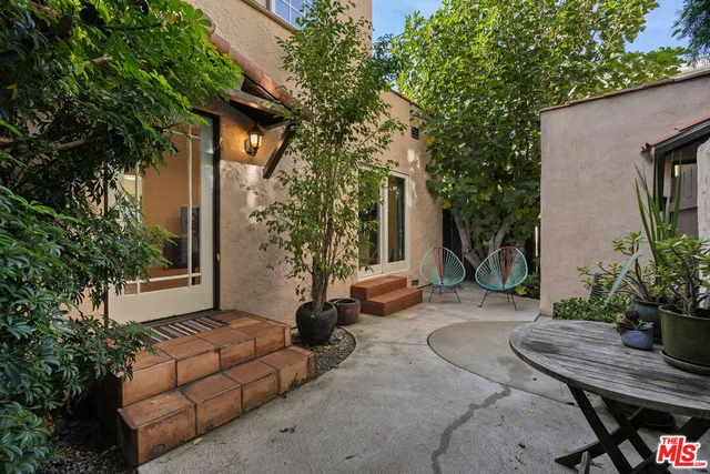 a view of a backyard with furniture and plants