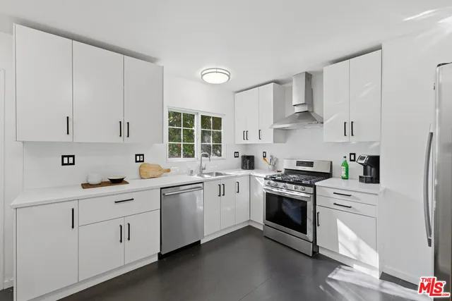 a kitchen with white cabinets and white appliances