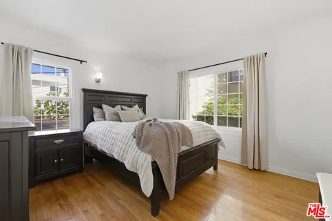 a bed sitting in a bedroom next to a window
