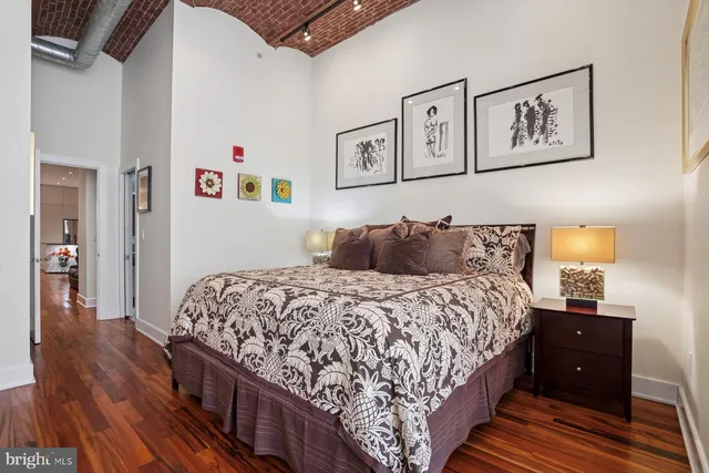 a bedroom with bed and wooden floor