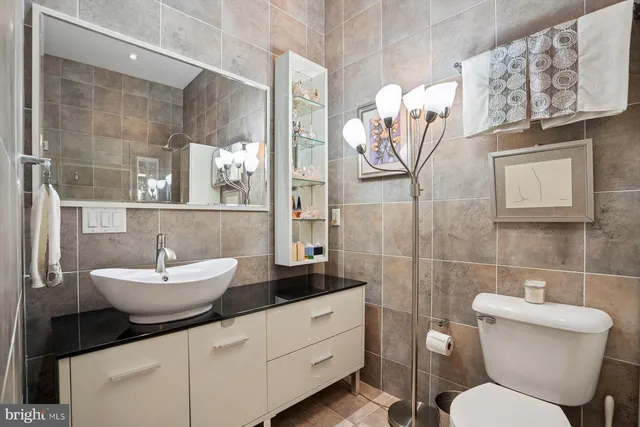 a bathroom with a sink mirror and toilet