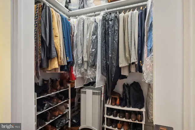 a view of walk in closet with clothes and shoes