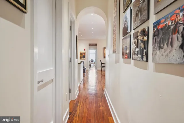 a view of a hallway with wooden floor and staircase