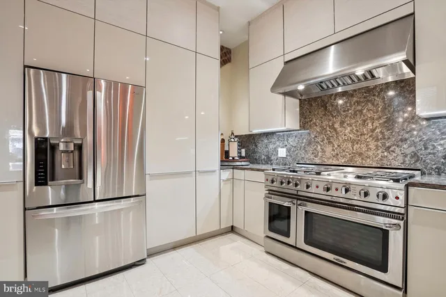 a kitchen with stainless steel appliances white cabinets and wooden floor