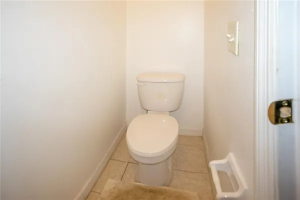 a white toilet sitting next to a white wall