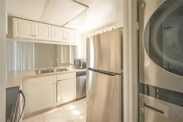 a kitchen with a sink a refrigerator and cabinets