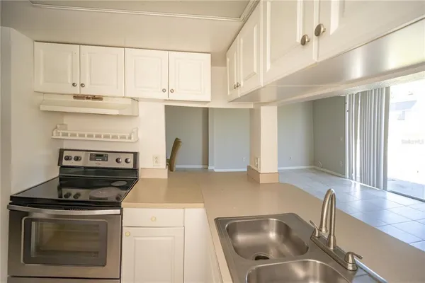 a kitchen with stainless steel appliances granite countertop a stove and a white cabinets