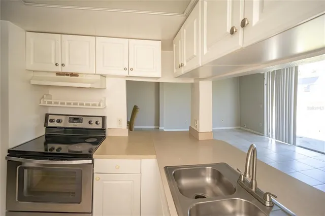 a kitchen with stainless steel appliances granite countertop a stove and a white cabinets