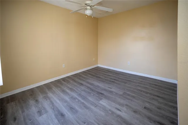 a view of a room with wooden floor and a ceiling fan