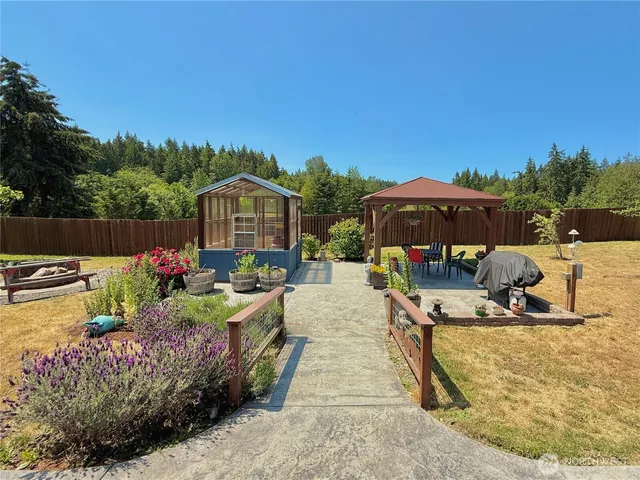 a view of a house with backyard water fountain and sitting area