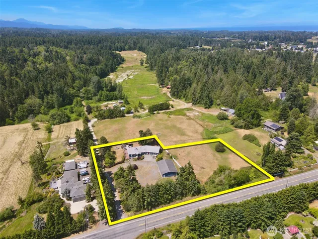 a aerial view of a house next to a yard with large tree