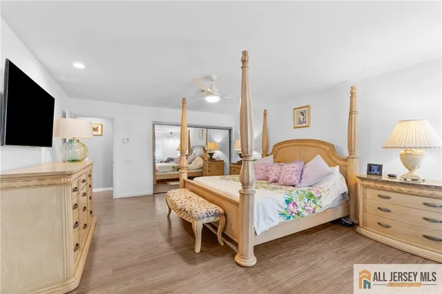 a bedroom with bed and a flat tv screen on dresser