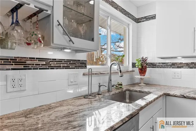 a kitchen with granite countertop a sink a stove and wooden cabinets