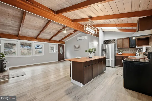 a kitchen with stainless steel appliances granite countertop a sink refrigerator and cabinets