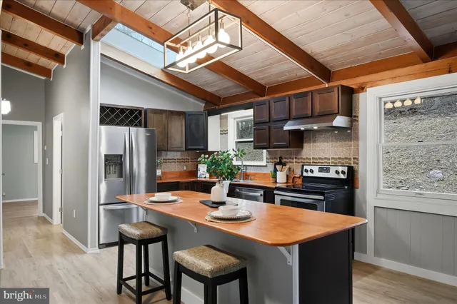 a kitchen with stainless steel appliances granite countertop a sink a stove and a refrigerator