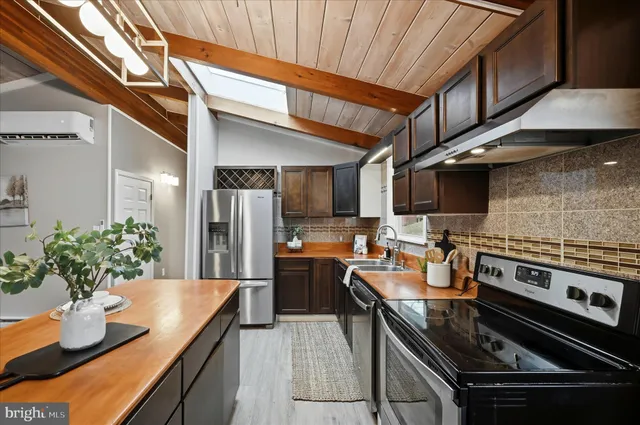 a kitchen with stainless steel appliances granite countertop a sink and a refrigerator