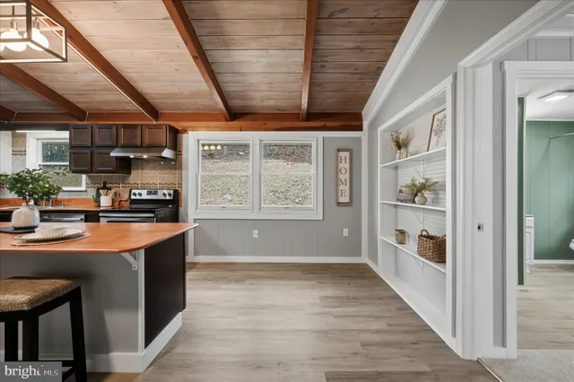 a view of empty room with wooden floor and window