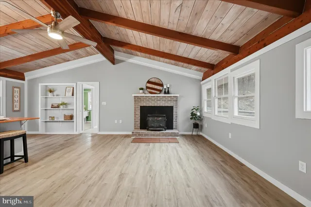 a living room with a fireplace and wooden floor