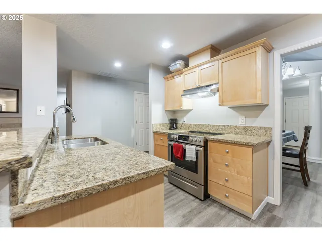 a kitchen with granite countertop sink and cabinets