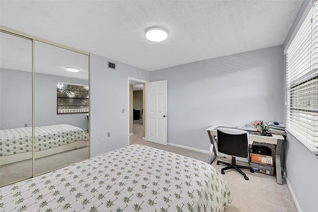 a bedroom with a bed a desk and chair