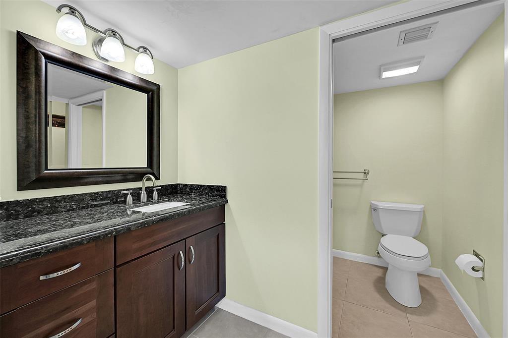 6109 Balboa Circle, Unit 305 Boca Raton, FL 33433 - Photo 20 of 22 a bathroom with a toilet sink and mirror
