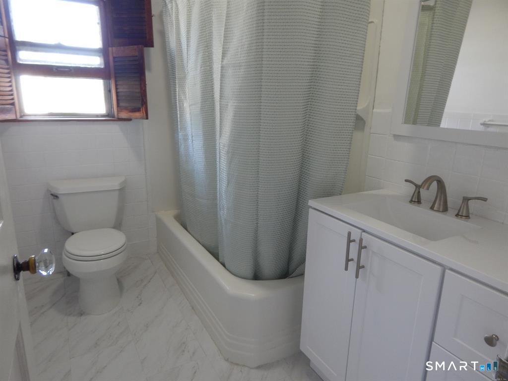 5 Clover Street Ansonia, CT 06401 - Photo 2 of 10 a bathroom with a sink a toilet and a mirror